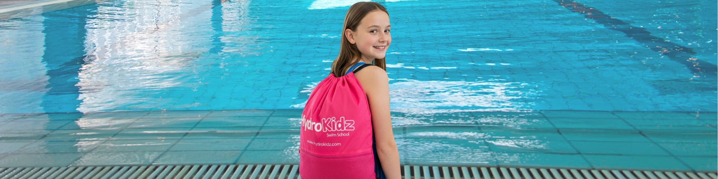 Cute pink octopus toy with yellow eyes holding credit card in HydroKidz swim school collection